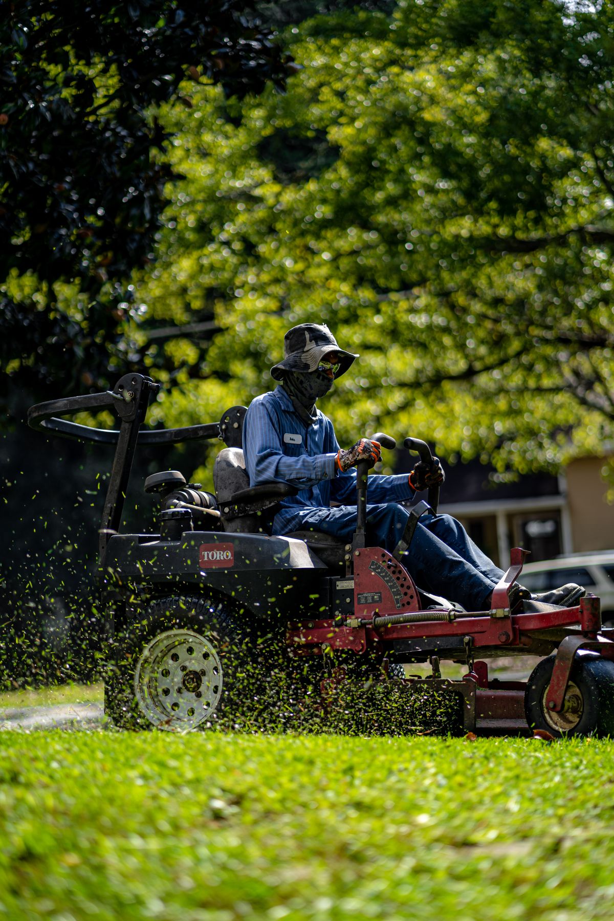 Grounds maintenance worker operating a ride-on lawn mower